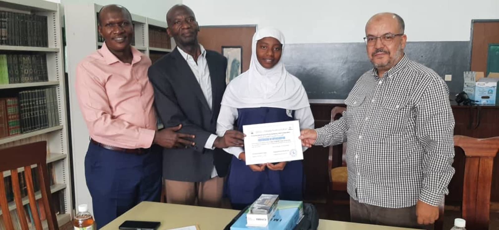 A student presented with a certificate in the ESSI Nyamirambo library