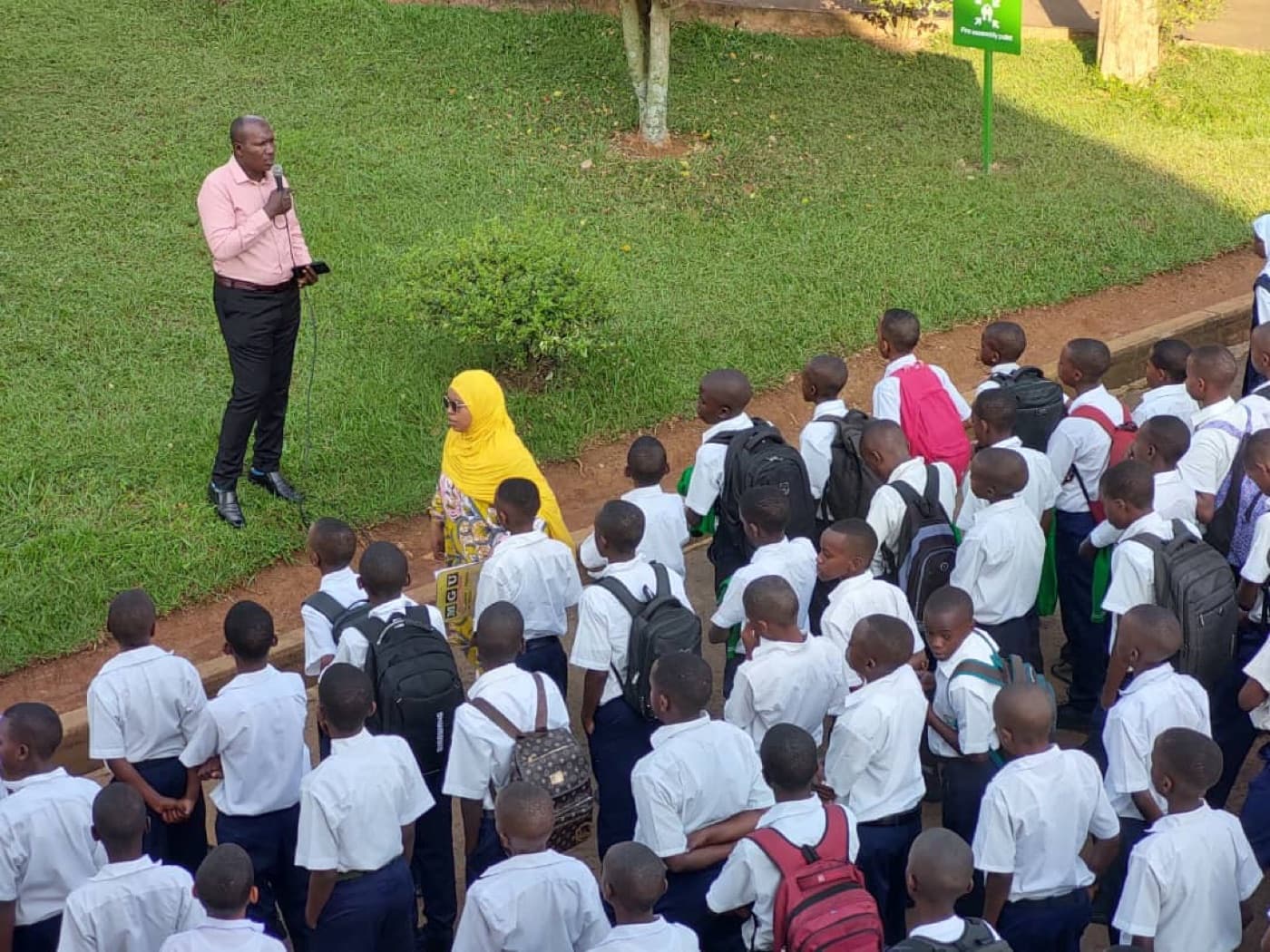 A school assembly with students gathered outdoors at ESSI Nyamirambo